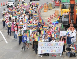 虹色のプラカードを掲げながら行進する「東京ラブパレード」の参加者ら＝東京都新宿区で２０１８年１０月８日午後３時５４分